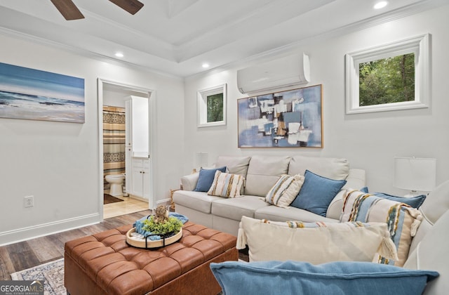 living room featuring a wall mounted AC, crown molding, ceiling fan, and wood-type flooring