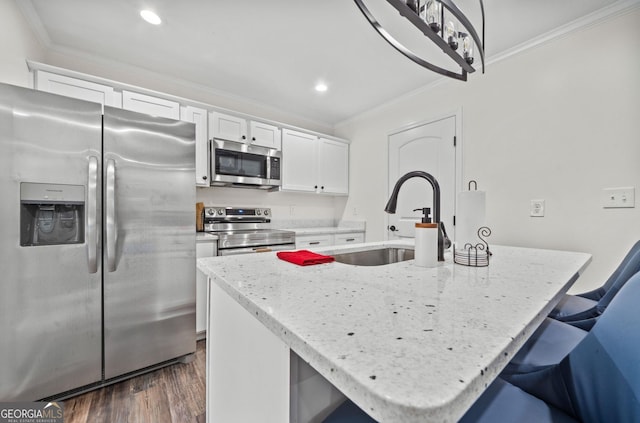 kitchen with sink, dark hardwood / wood-style floors, an island with sink, white cabinets, and appliances with stainless steel finishes