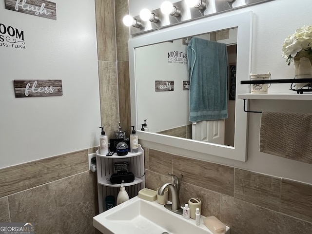 bathroom with tile walls and sink