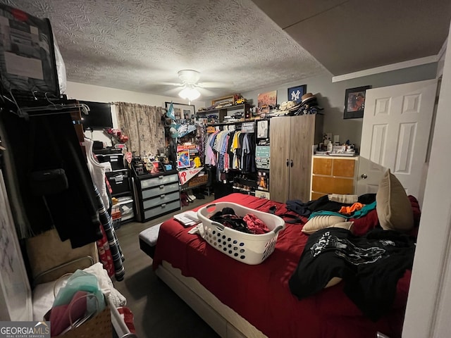 bedroom with a textured ceiling, crown molding, and ceiling fan