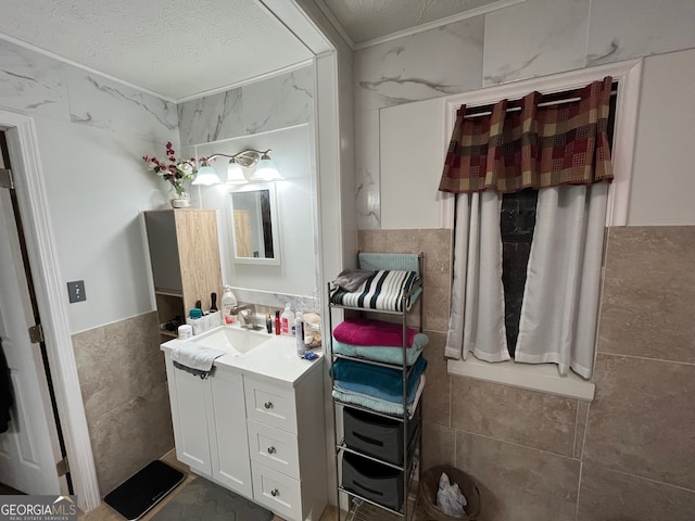 bathroom featuring tile walls, a textured ceiling, and vanity