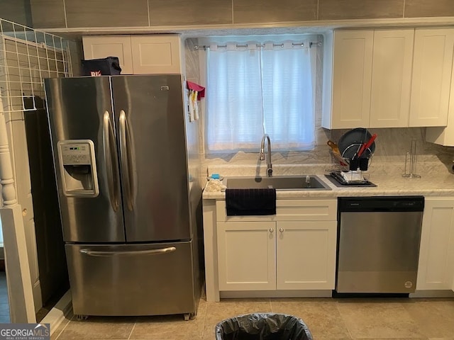 kitchen with light tile patterned floors, white cabinets, appliances with stainless steel finishes, and sink