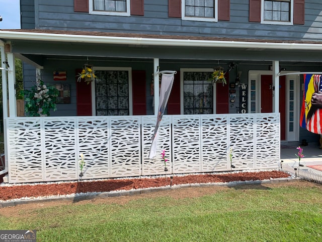 entrance to property with a lawn and covered porch