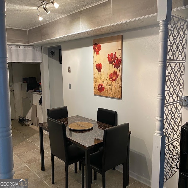 tiled dining space with a textured ceiling