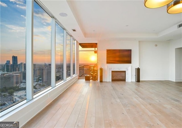 3630 Peachtree Rd Unit Ph3302, Atlanta, GA 30326 - unfurnished living room featuring a tray ceiling, hardwood / wood-style flooring, and a fireplace