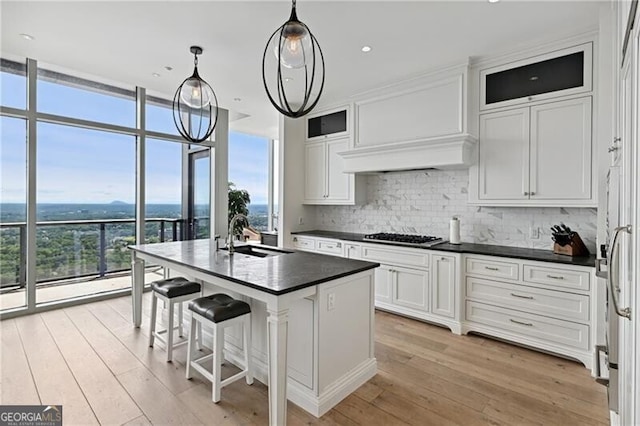 3630 Peachtree Rd Unit Ph3302, Atlanta, GA 30326 - kitchen with a sink, dark countertops, decorative backsplash, white cabinetry, and light wood finished floors
