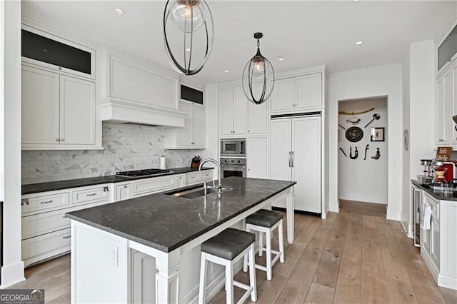 3630 Peachtree Rd Unit Ph3302, Atlanta, GA 30326 - kitchen with a sink, built in appliances, backsplash, white cabinetry, and light wood-type flooring