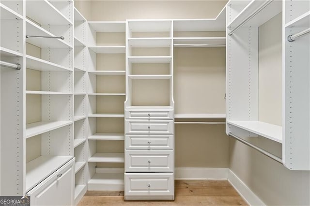 walk in closet with light hardwood / wood-style floors