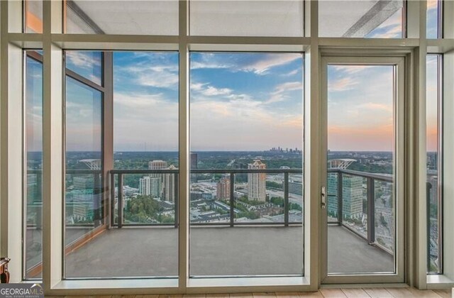 doorway to outside featuring a wealth of natural light, light wood-type flooring, and expansive windows