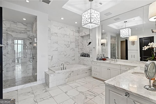 bathroom featuring a raised ceiling, vanity, and independent shower and bath