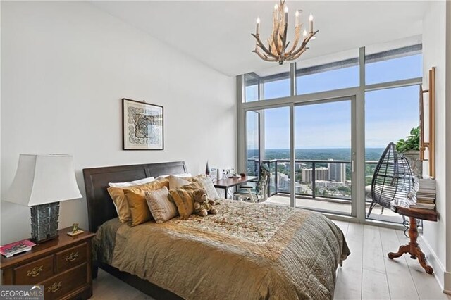 bedroom with a wall of windows, light hardwood / wood-style floors, a notable chandelier, and access to exterior