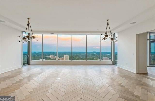 unfurnished room with a chandelier and light parquet floors