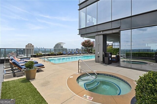 view of swimming pool with a hot tub and a patio area