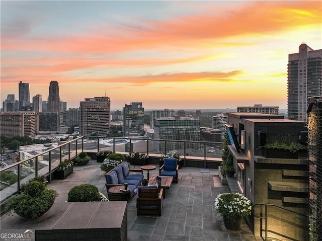 patio terrace at dusk featuring a balcony