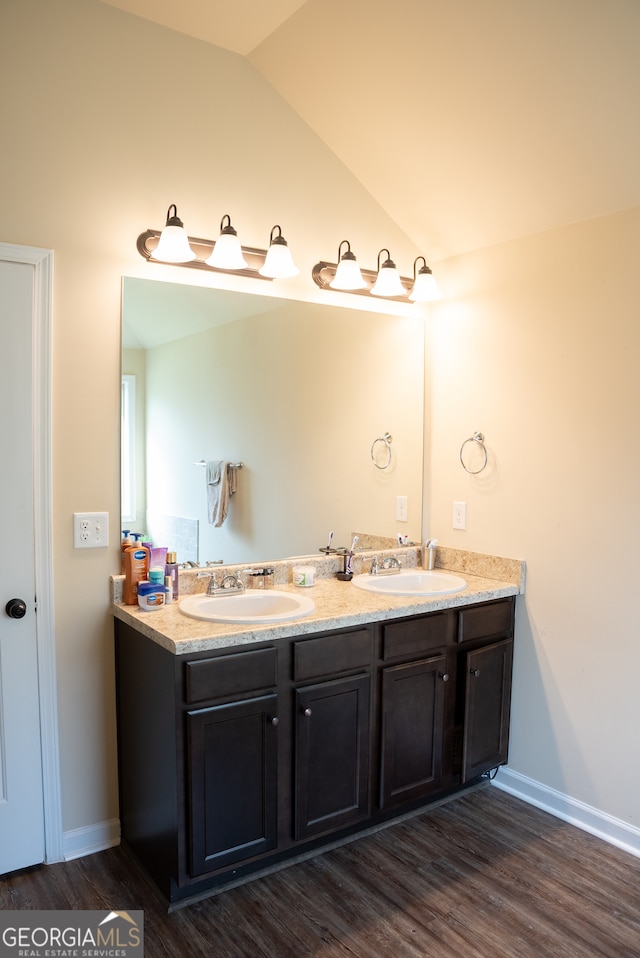 bathroom featuring wood-type flooring, lofted ceiling, and vanity