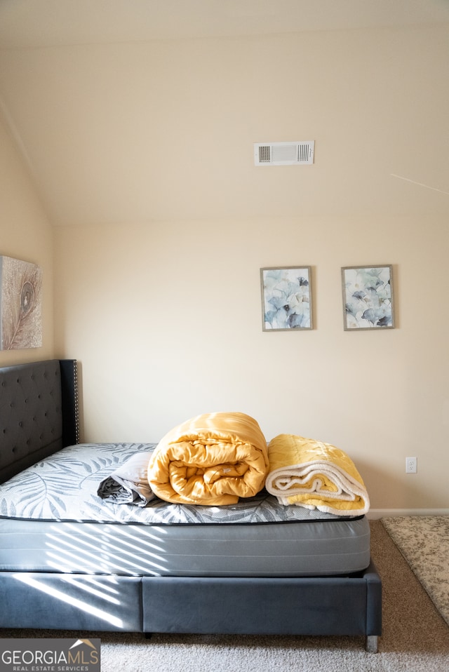 carpeted bedroom with vaulted ceiling