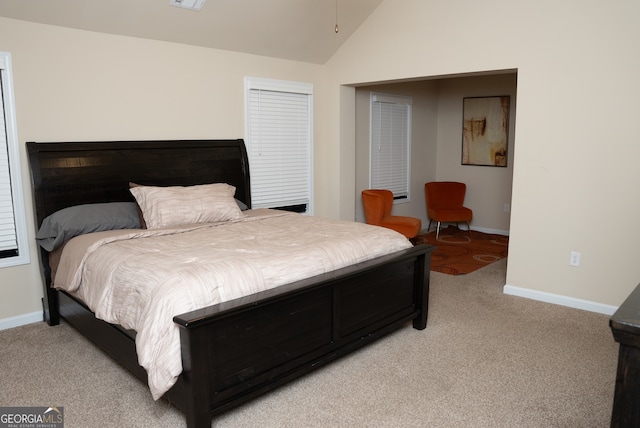 bedroom featuring light colored carpet and lofted ceiling