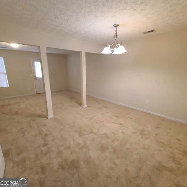 basement featuring a textured ceiling and light colored carpet