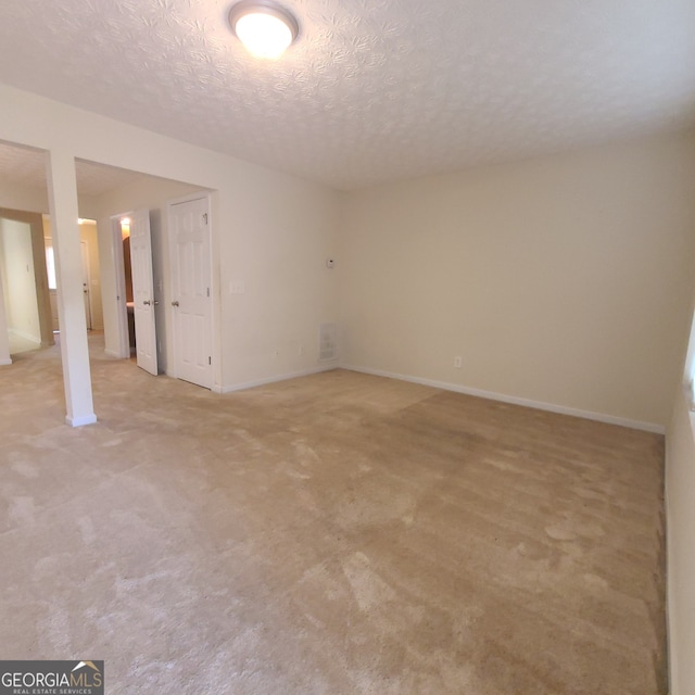 carpeted spare room with a textured ceiling