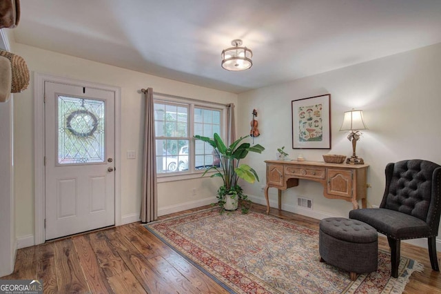 entryway with baseboards, visible vents, and wood finished floors