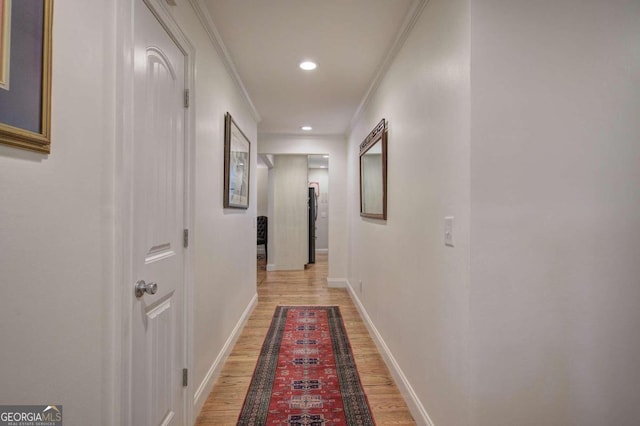 corridor with baseboards, light wood finished floors, recessed lighting, and crown molding