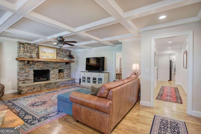 living area featuring a fireplace, light wood finished floors, a ceiling fan, coffered ceiling, and baseboards