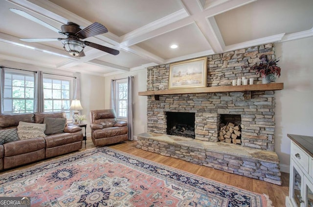 living room with a stone fireplace, coffered ceiling, beam ceiling, and light wood-style floors