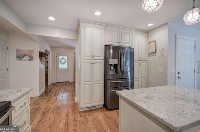 kitchen featuring recessed lighting, hanging light fixtures, appliances with stainless steel finishes, light wood-style floors, and white cabinetry