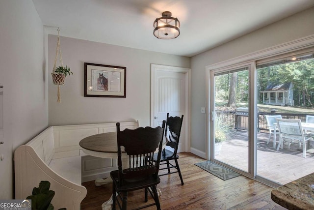 dining space featuring light wood-type flooring and baseboards