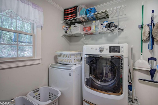 laundry room featuring laundry area, washing machine and clothes dryer, and crown molding