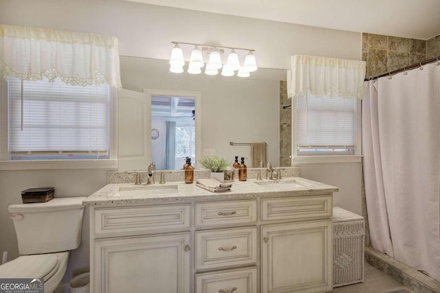 bathroom featuring a shower with shower curtain, a sink, and toilet