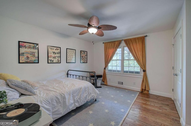 bedroom with a ceiling fan, light wood-style flooring, and baseboards