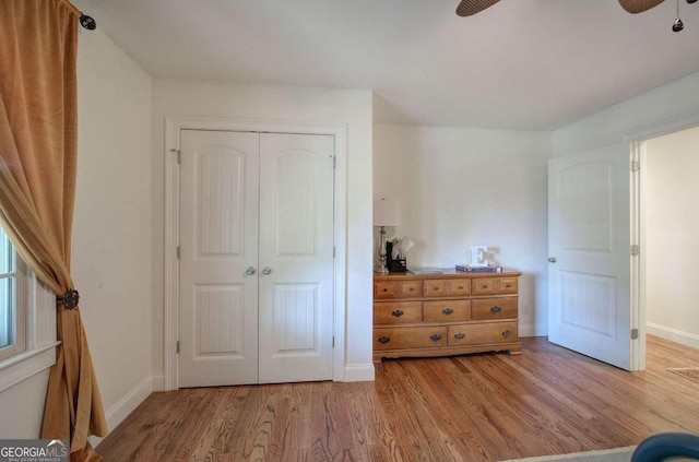 unfurnished bedroom featuring light wood-type flooring, baseboards, and a closet