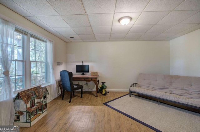 office featuring a paneled ceiling, visible vents, baseboards, and wood finished floors