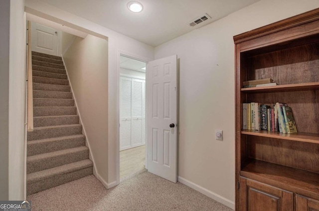 stairway featuring carpet floors, baseboards, and visible vents