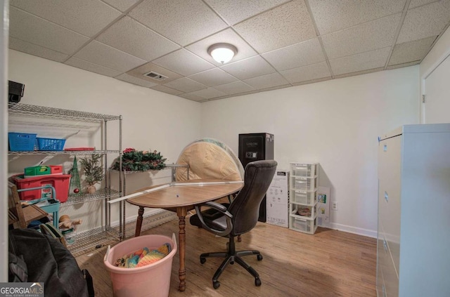 office area featuring a paneled ceiling, baseboards, visible vents, and wood finished floors