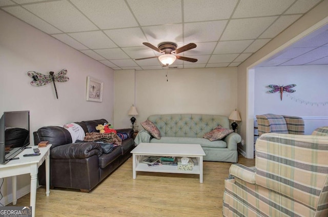 living room with a paneled ceiling, light wood-style flooring, and a ceiling fan