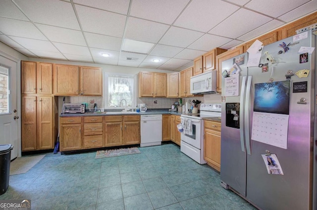 kitchen featuring a paneled ceiling, white appliances, a sink, visible vents, and decorative backsplash