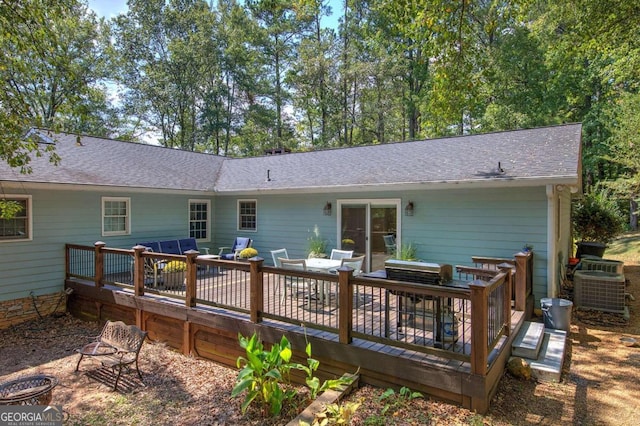 back of property with a shingled roof and a deck