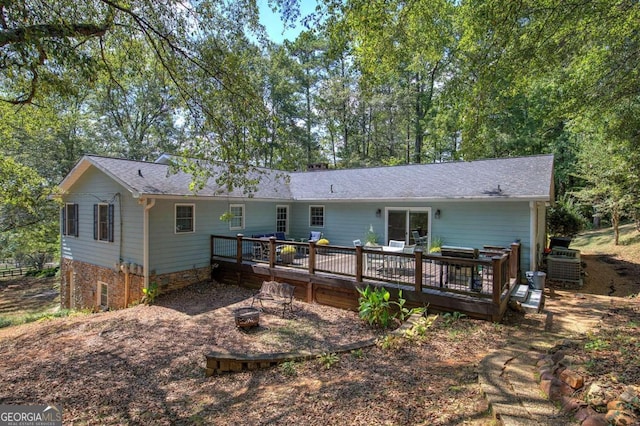 rear view of property featuring an outdoor fire pit and a wooden deck