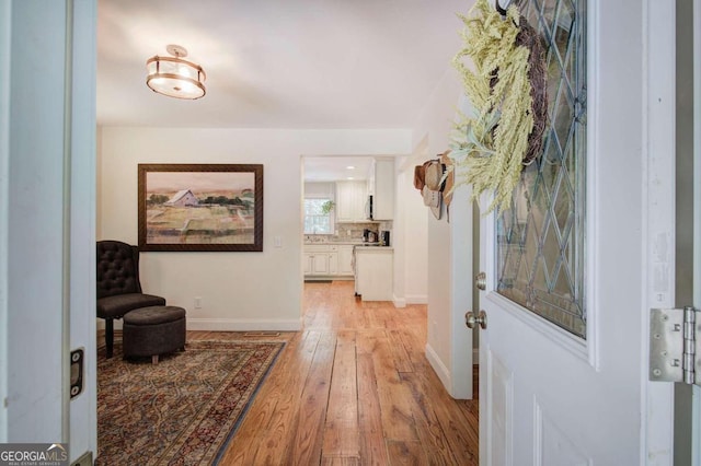 hallway with light wood-style flooring and baseboards