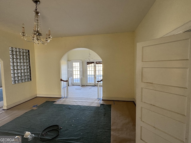 hall featuring a notable chandelier and lofted ceiling