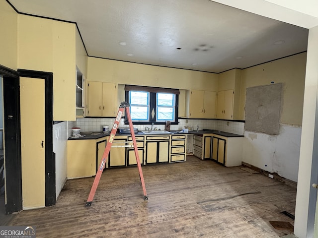 kitchen with cream cabinetry, wood-type flooring, sink, and tasteful backsplash