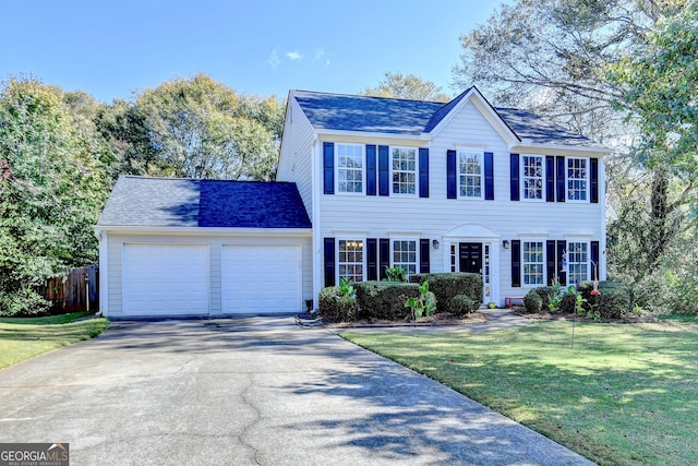 colonial home featuring a front lawn and a garage