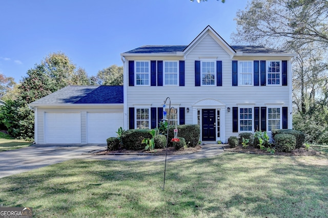 colonial inspired home featuring a garage and a front lawn