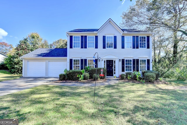 colonial house with a front yard and a garage