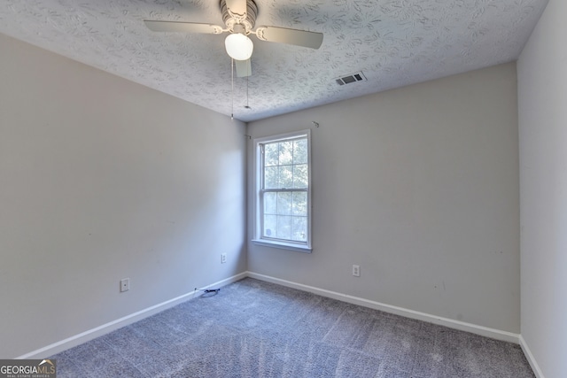 carpeted spare room with a textured ceiling and ceiling fan