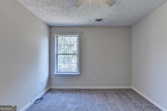 spare room with ceiling fan, a textured ceiling, and carpet flooring