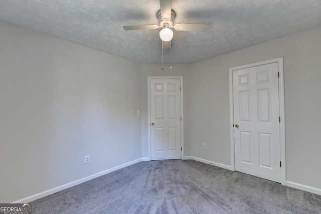 carpeted spare room with a textured ceiling and ceiling fan