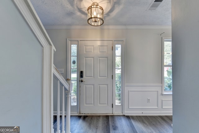 entryway with crown molding, a textured ceiling, and dark hardwood / wood-style floors